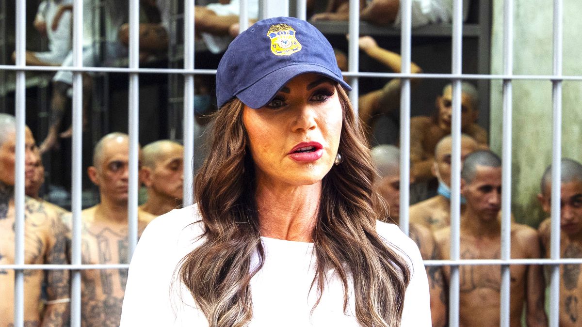 As prisoners stand looking out from a cell, Department of Homeland Security Secretary Kristi Noem speaks during a tour of the Terrorist Confinement Center (CECOT) on March 26, 2025 in Tecoluca, El Salvador. The Trump administration deported 238 alleged members of the Venezuelan criminal organizations 'Tren De Aragua' and Mara Salvatrucha with only 23 being members of the Mara. Nayib Bukele president of El Salvador announced that his government will receive the alleged members of the gang to be taken to CECOT. (Photo by Alex Brandon-Pool/Getty Images)